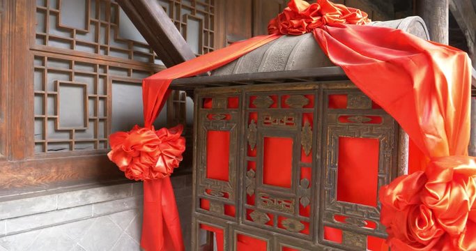 Ancient traditional Chinese Bridal sedan chair with red flower ribbon and wooden door window