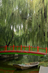 Old bridge and boat with willow trees in Changpu river park Beijing China