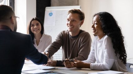 Company boss greeting client start negotiations shake hands express respect
