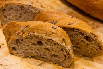A piece of bread with cereals on a cutting board