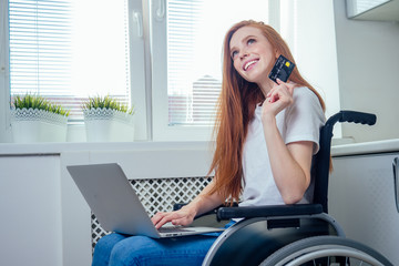 Confident happy redhaired ginger businesswoman student in wheelchair doing online shopping with...