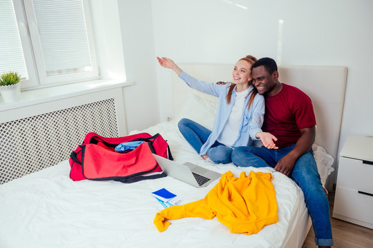 latin hispanic man and redhaired ginger woman unpacking in new house apartment