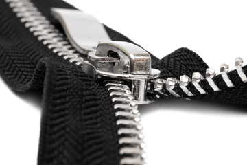 macro of open metal zipper with black fabric isolated on white background