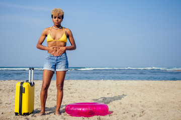 beautiful sad and sick african american woman in yellow swimsuit and denim shorts holding hands on...