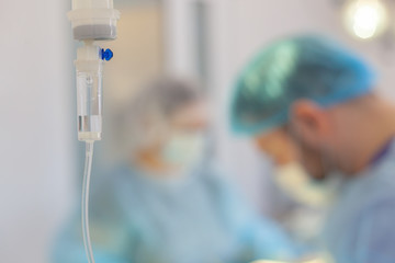 Hospital. Surgeon operates in the operating room. Dropper on a blurry background with operating doctors