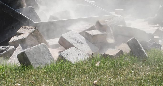 Front end loader machine scoops up a load of pavers into the bucket