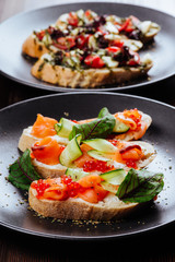 Italian Appetizer Bruschetta with roasted tomatoes, mozzarella cheese, garlic and herbs on wooden table