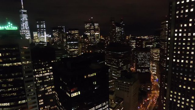 Flying over the buildings and skyscrapers of New York City at night aerial