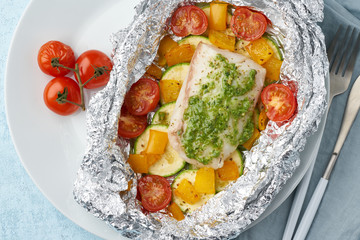 Foil pack dinner with white fish. Oven baked fillet of cod, pike perch with vegetables