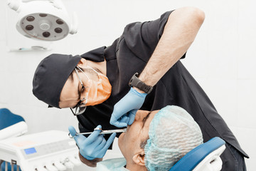 Patient and dentist during implant placement operation. Real operation. Tooth extraction, implants....