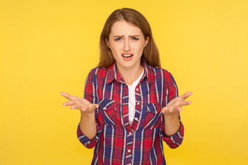 What do you want? Portrait of angry disgruntled ginger girl in casual shirt asking who why make this conflict, looking with annoyed indignant expression. studio shot isolated on yellow background