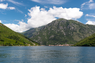 Landscape of mountains, sea and the small towns in the Boka Kotor bay of the Mediterranean Sea sunny day and white clouds. Montenegro.