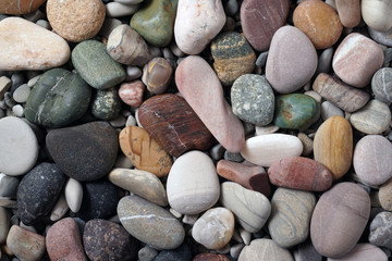 Fototapeta na wymiar Gravel pattern of colored stones. Abstract nature pebbles background.Small sea stones on the beach, vacation at sea. Top view 