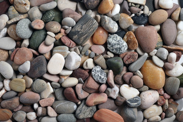 Gravel pattern of colored stones. Abstract nature pebbles background.Small sea stones on the beach, vacation at sea. Top view      