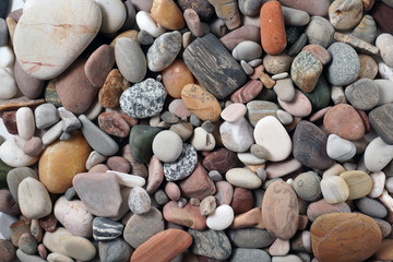 Gravel pattern of colored stones. Abstract nature pebbles background.Small sea stones on the beach, vacation at sea. Top view      