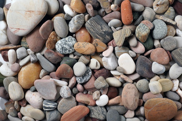 Gravel pattern of colored stones. Abstract nature pebbles background.Small sea stones on the beach, vacation at sea. Top view      