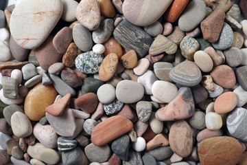Gravel pattern of colored stones. Abstract nature pebbles background.Small sea stones on the beach, vacation at sea. Top view      