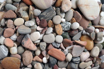 Gravel pattern of colored stones. Abstract nature pebbles background.Small sea stones on the beach, vacation at sea. Top view      
