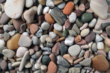 Gravel pattern of colored stones. Abstract nature pebbles background.Small sea stones on the beach, vacation at sea. Top view      