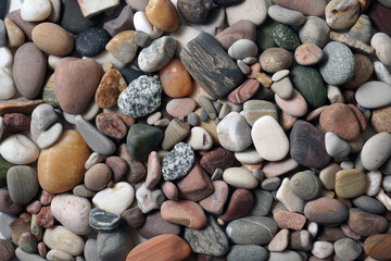 Gravel pattern of colored stones. Abstract nature pebbles background.Small sea stones on the beach, vacation at sea. Top view      