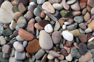 Gravel pattern of colored stones. Abstract nature pebbles background.Small sea stones on the beach, vacation at sea. Top view      