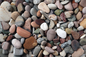 Gravel pattern of colored stones. Abstract nature pebbles background.Small sea stones on the beach, vacation at sea. Top view      