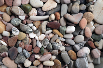 Gravel pattern of colored stones. Abstract nature pebbles background.Small sea stones on the beach, vacation at sea. Top view      