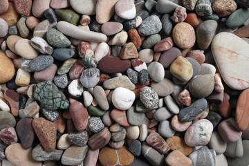 Gravel pattern of colored stones. Abstract nature pebbles background.Small sea stones on the beach, vacation at sea. Top view      