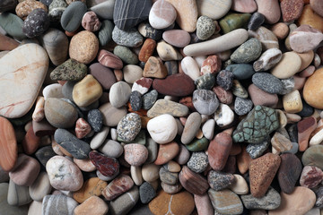 Gravel pattern of colored stones. Abstract nature pebbles background.Small sea stones on the beach, vacation at sea. Top view      