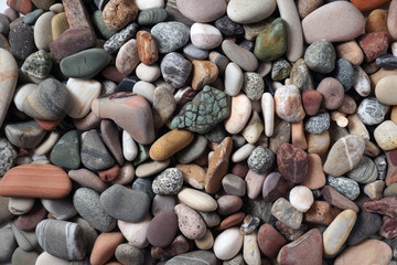 Gravel pattern of colored stones. Abstract nature pebbles background.Small sea stones on the beach, vacation at sea. Top view      
