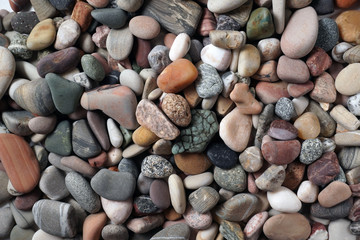 Gravel pattern of colored stones. Abstract nature pebbles background.Small sea stones on the beach, vacation at sea. Top view      