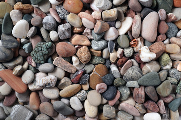 Gravel pattern of colored stones. Abstract nature pebbles background.Small sea stones on the beach, vacation at sea. Top view      