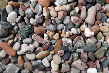 Gravel pattern of colored stones. Abstract nature pebbles background.Small sea stones on the beach, vacation at sea. Top view      