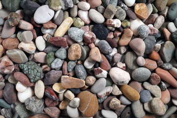 Gravel pattern of colored stones. Abstract nature pebbles background.Small sea stones on the beach, vacation at sea. Top view      