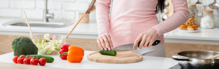 Woman preparing fresh salad at kitchen, panorama