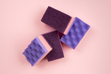 Kitchen sponges for washing dishes and other domestic needs on pink background