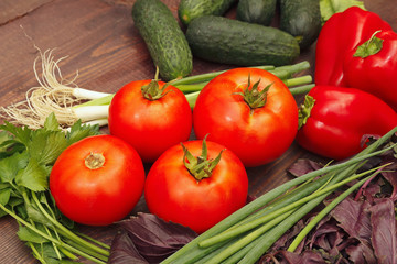 Fresh summer vegetables and greens on a wooden table
