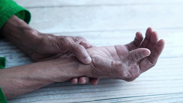 senior women rubbing wrist and thumb,