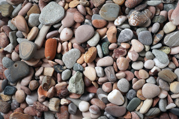 Gravel pattern of colored stones with shell. Abstract nature pebbles background.Small sea stones on the beach, vacation at sea. Top view   