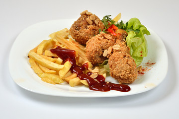 Food from a chicken restaurant with vegetables and sauce.