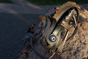 Fragment of a chamelion made of metal on the sunny day.