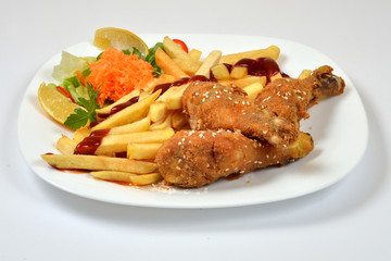 Food from a chicken restaurant with vegetables and sauce.