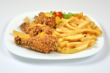 Food from a chicken restaurant with vegetables and sauce.