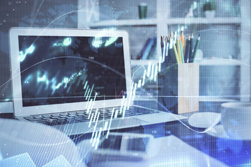 Stock market graph on background with desk and personal computer. Multi exposure. Concept of financial analysis.