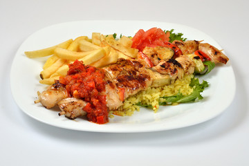 Food from a chicken restaurant with vegetables and sauce.