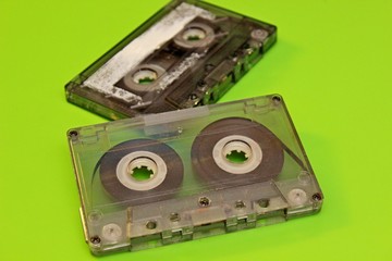 Old audio cassettes are located on a green background