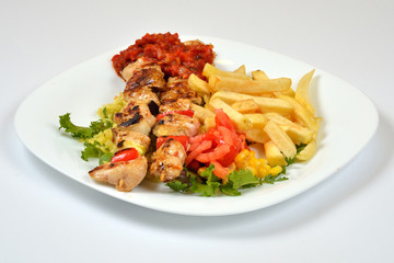 Food from a chicken restaurant with vegetables and sauce.