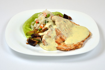 Food from a chicken restaurant with vegetables and sauce.