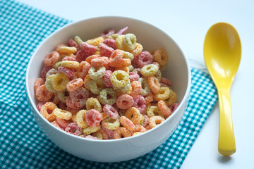 colorful ring corn flakes in a bowl with spoon 