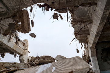 Destruction of buildings. A huge gap in the concrete slab with concrete fragments hanging on the...